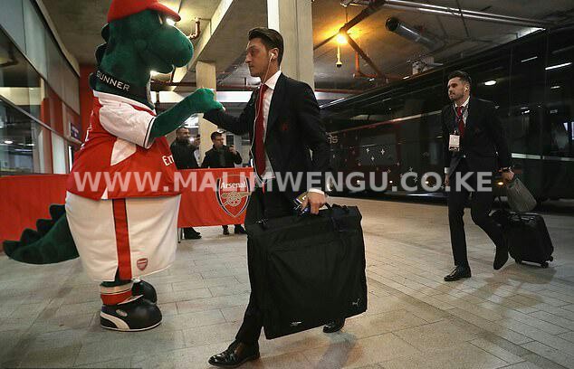 Ozil shaking hands with Gunnersaurus before a match